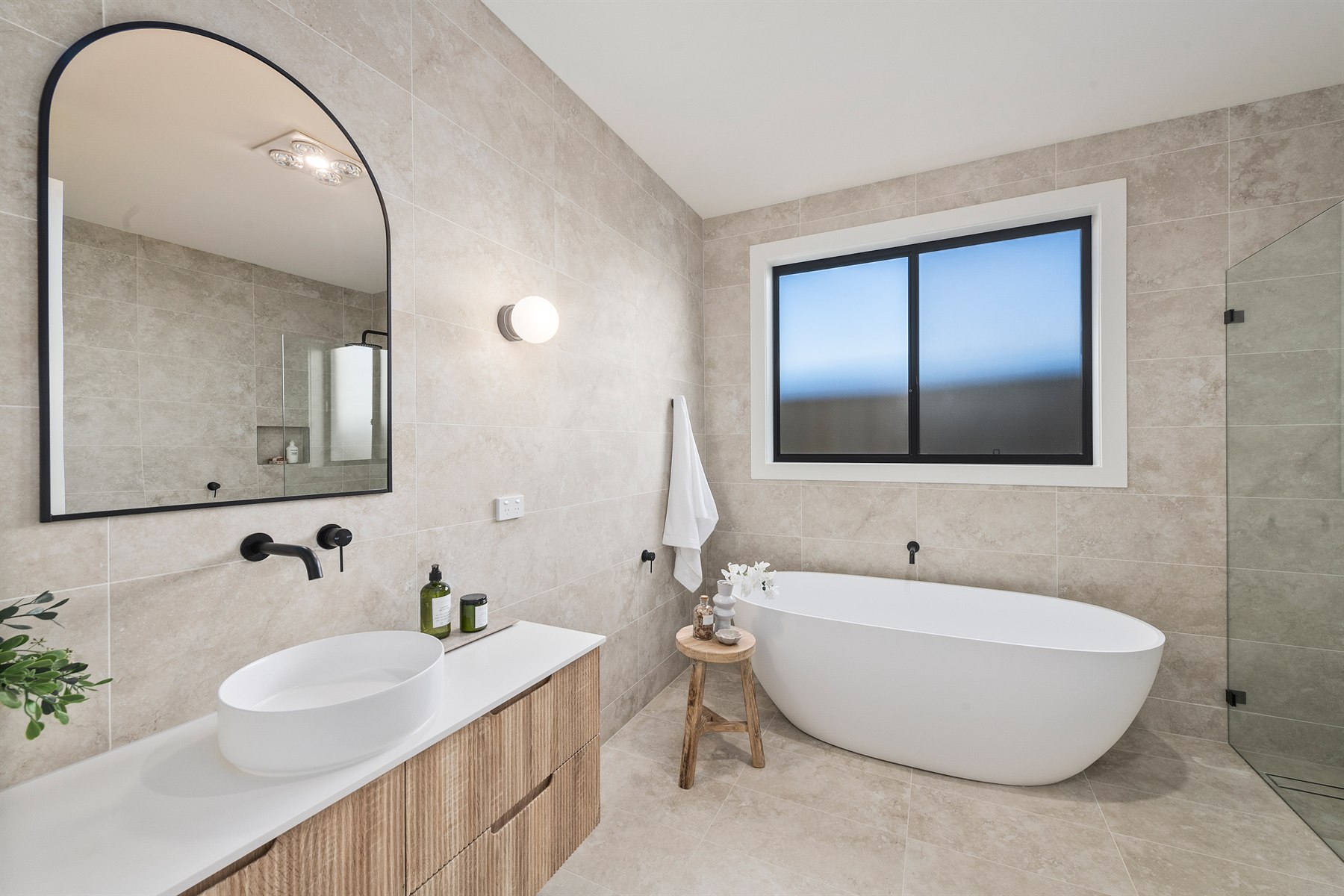 Finished bathroom with freestanding bath and custom vanity